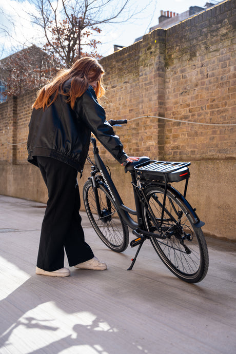 A female checking the height of the seat on an eBike